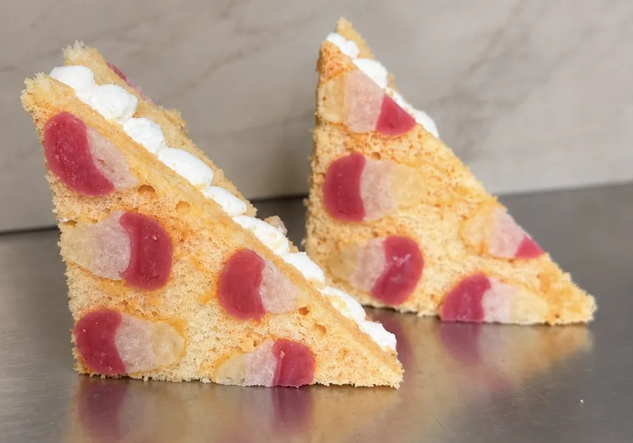 Two vanilla cake sandwiches with pink and red designs baked into the cake, filled with piped ermine frosting.